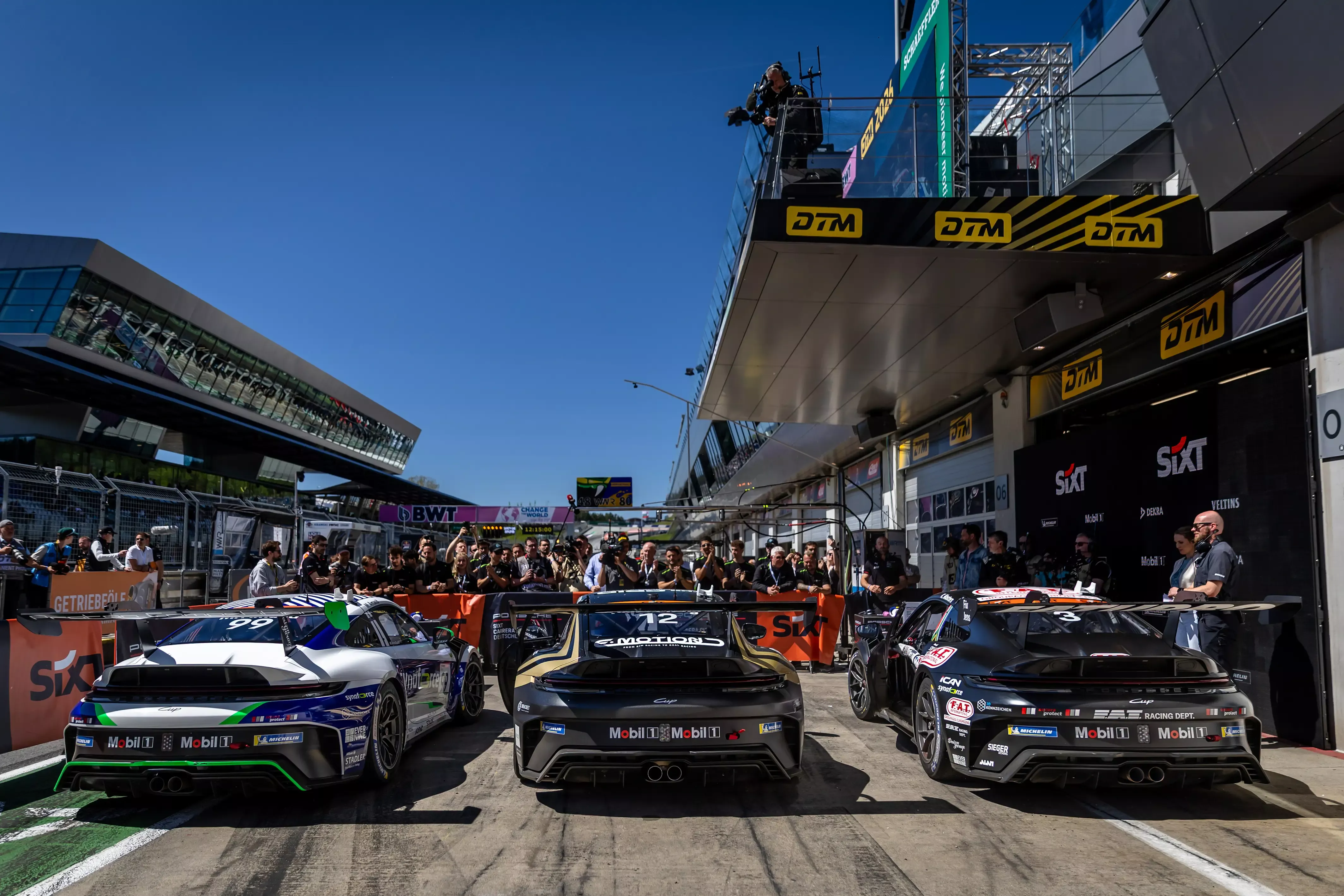 Fahrzeuge von Proton Competition in der Boxengasse beim Porsche Carrera Cup Deutschland 2026