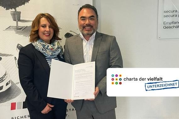 Pratrick Pond und Tanja Pond von secura protect halten Urkunde der Charta der Vielfalt