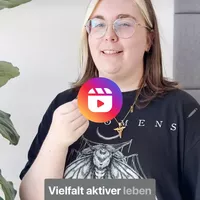 Junge Mitarbeiterin von secura protect mit Brille und heller Strähne lächelt in die Kamera und hält ein Mikrofon. Auf dem Bild steht der Text: „Vielfalt aktiver leben“. Das Reel gibt 3 persönliche Tipps von Nadja, wie Vielfalt am Arbeitsplatz und im Allta